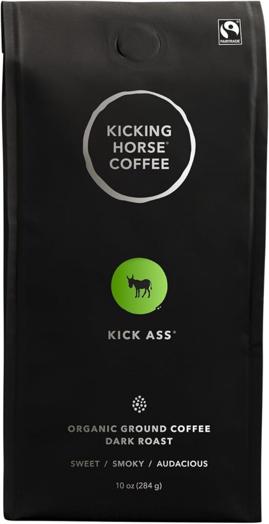 Black bag of Kicking Horse Coffee's "Kick Ass" dark roast, featuring a green circle with a donkey silhouette and labeled as organic ground coffee. The packaging highlights the flavor notes as sweet, smoky, and audacious, and includes a Fairtrade logo, emphasizing it as Canadian roasted coffee.