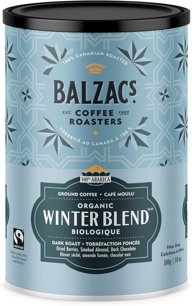Light blue tin of Balzac’s Coffee Roasters Organic Winter Blend, labeled as 100% Canadian roasted and 100% Arabica. The dark roast features seasonal coffee flavours including dried berries, smoked almond, and dark chocolate, and displays both English and French descriptions along with a Fairtrade logo